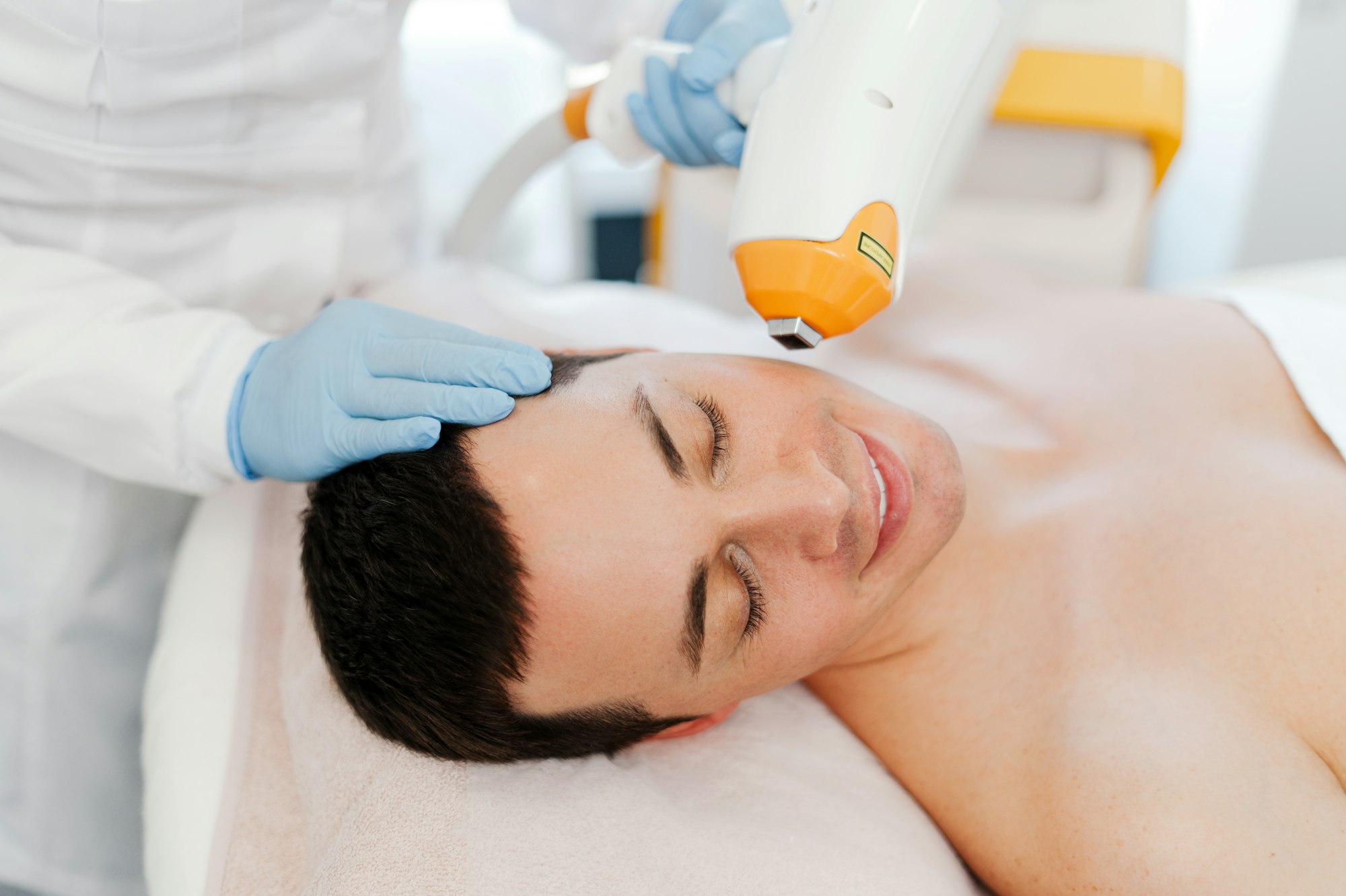 handsome-young-man-getting-cosmetic-procedures-beautician-using-laser-removing-facial-hair