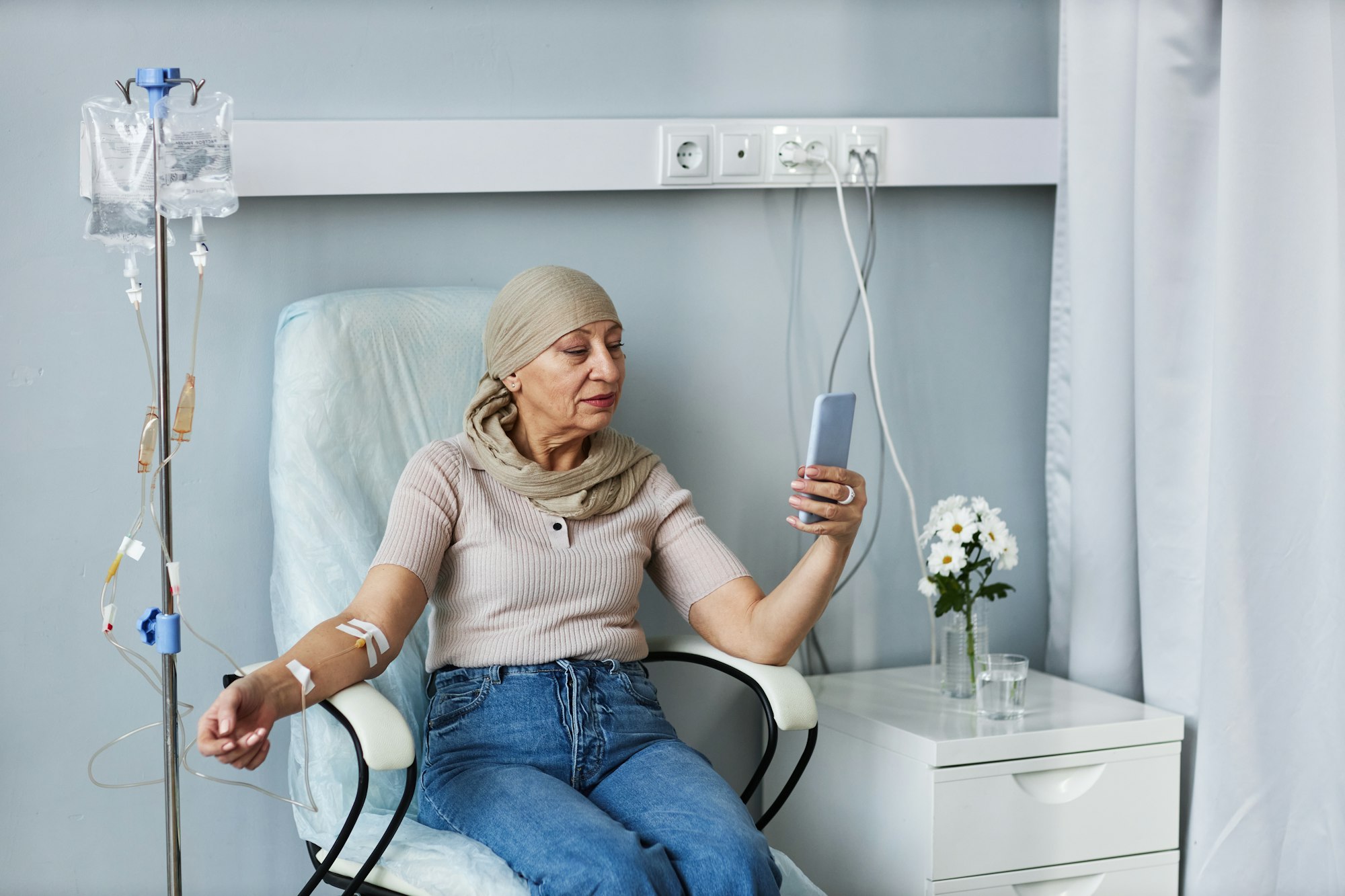 senior-woman-with-iv-drip-using-smartphone